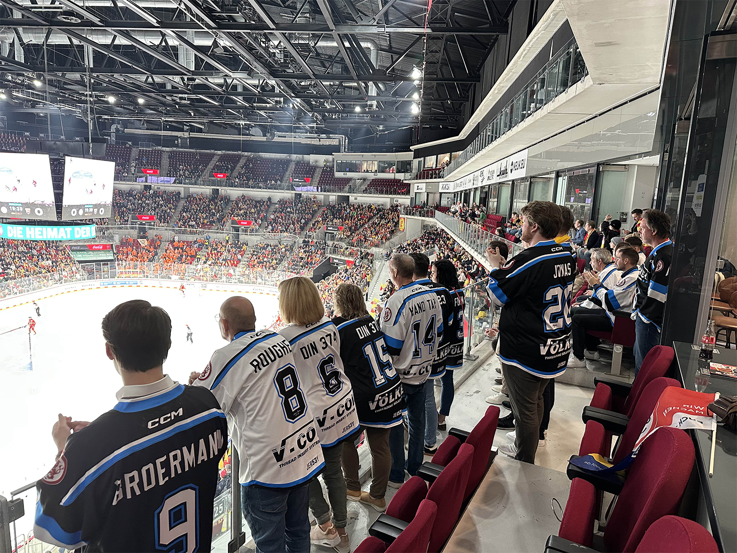 Bild mit Blick über die Schulter von Teilnehmer des Hockey Days als sie das Spiel des DEGs beobachten