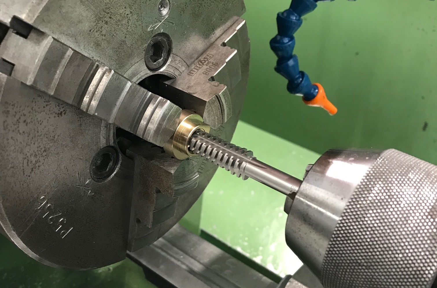 Nahaufnahme eines Maschinengewindebohrers, der in einer Drehmaschine arbeitet.