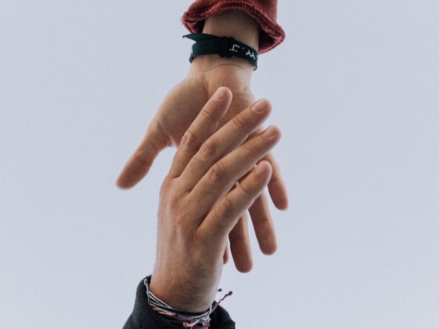 Hands touching in front of a plain background