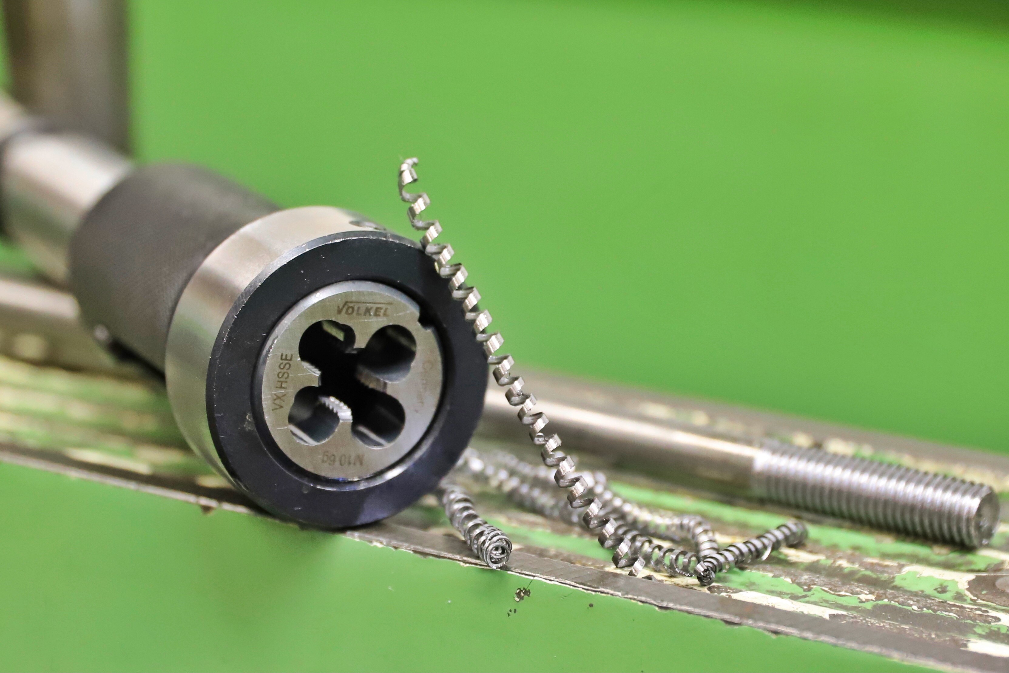Gewindeschneidewerkzeug "VÖLKEL" mit Metallspänen und Gewindestange.