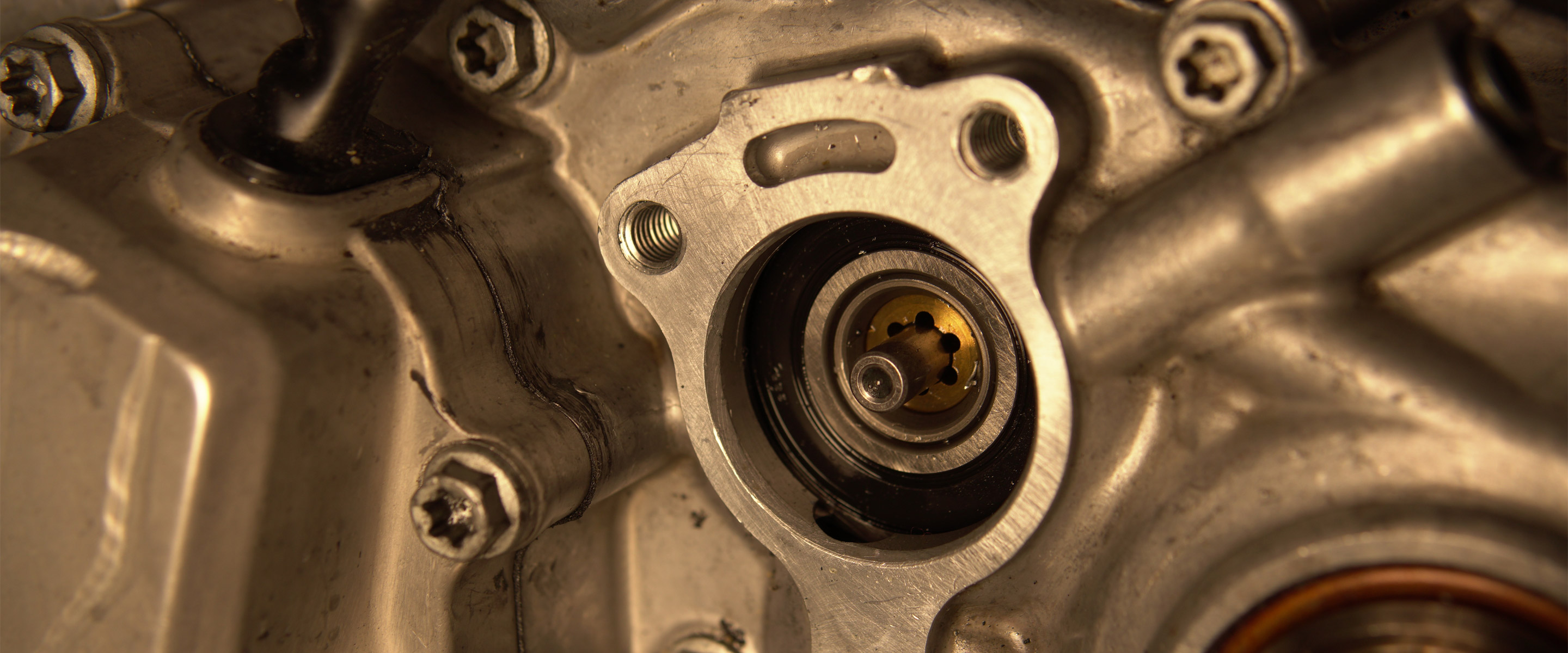 Nahaufnahme eines mechanischen Bauteils mit Schrauben und Metalloberflächen.