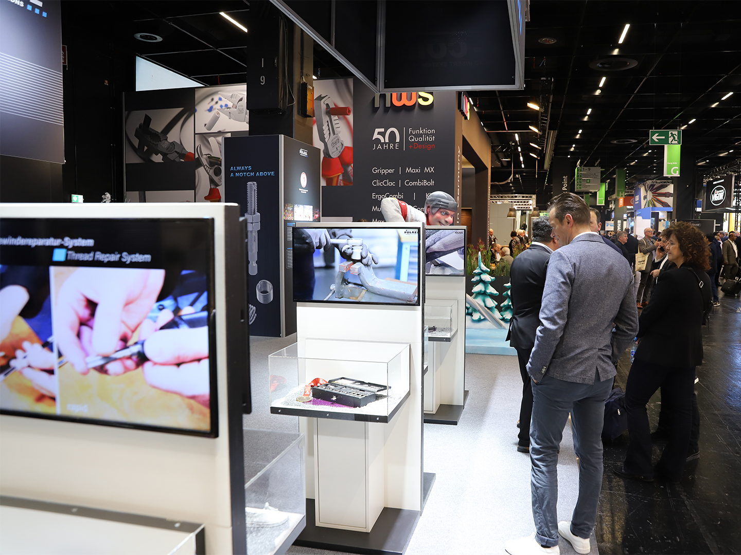 Ausstellung von Werkzeugen und Hardware auf der Eisenwarenmesse 2024, mit Menschen, die die Stände und Displays erkunden.