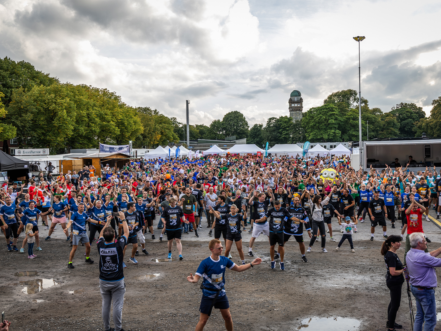 Große Menge von Teilnehmern, darunter VÖLKEL-Mitarbeiter, beim Aufwärmen. Keywords: Firmenlauf Remscheid, VÖLKEL, Team, Sportevent 2025