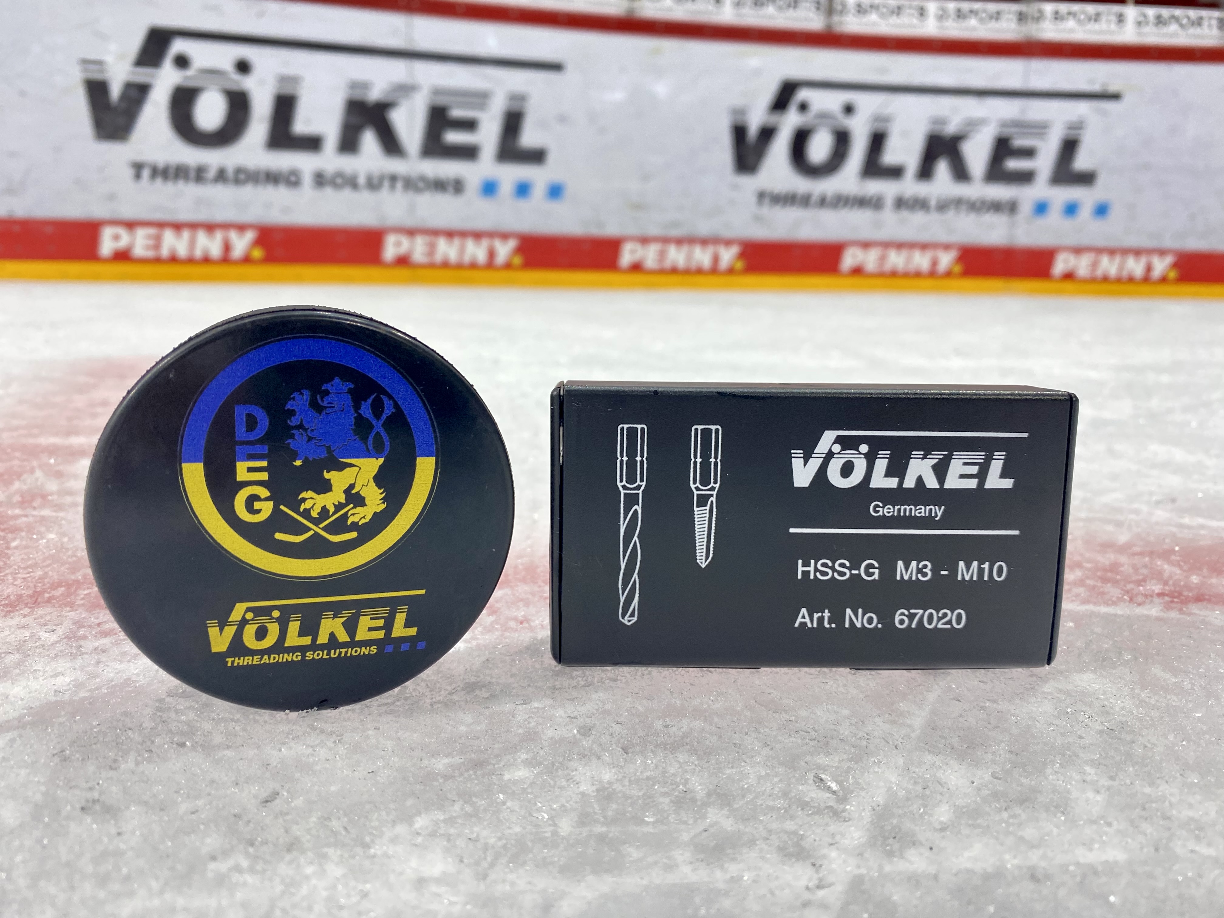 Hockey-Puck mit Ukraine-Design und Peace-Zeichen neben einem VÖLKEL Gewindeschneid-Set