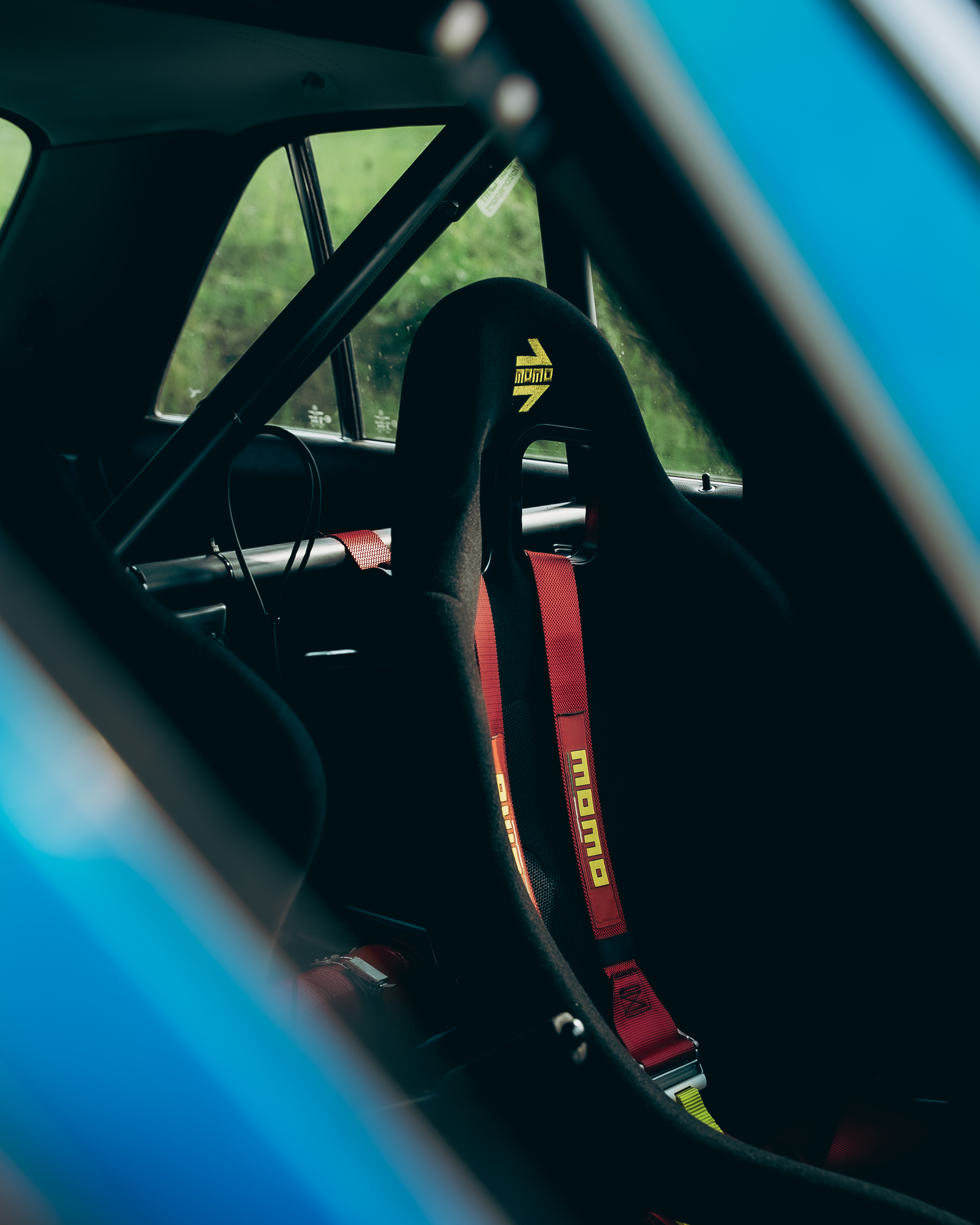 Mercedes-Benz 280E W123 MOMO Sitz Rallye Detailaufnahme des MOMO-Rennsitzes mit roten Hosenträgergurten im Mercedes-Benz 280E W123, Carrera Panamericana.