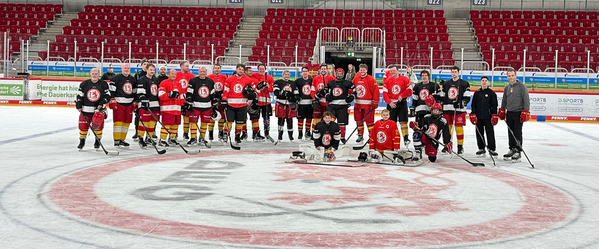 Eishockeymannschaft auf dem Eis vor leeren Tribünen.