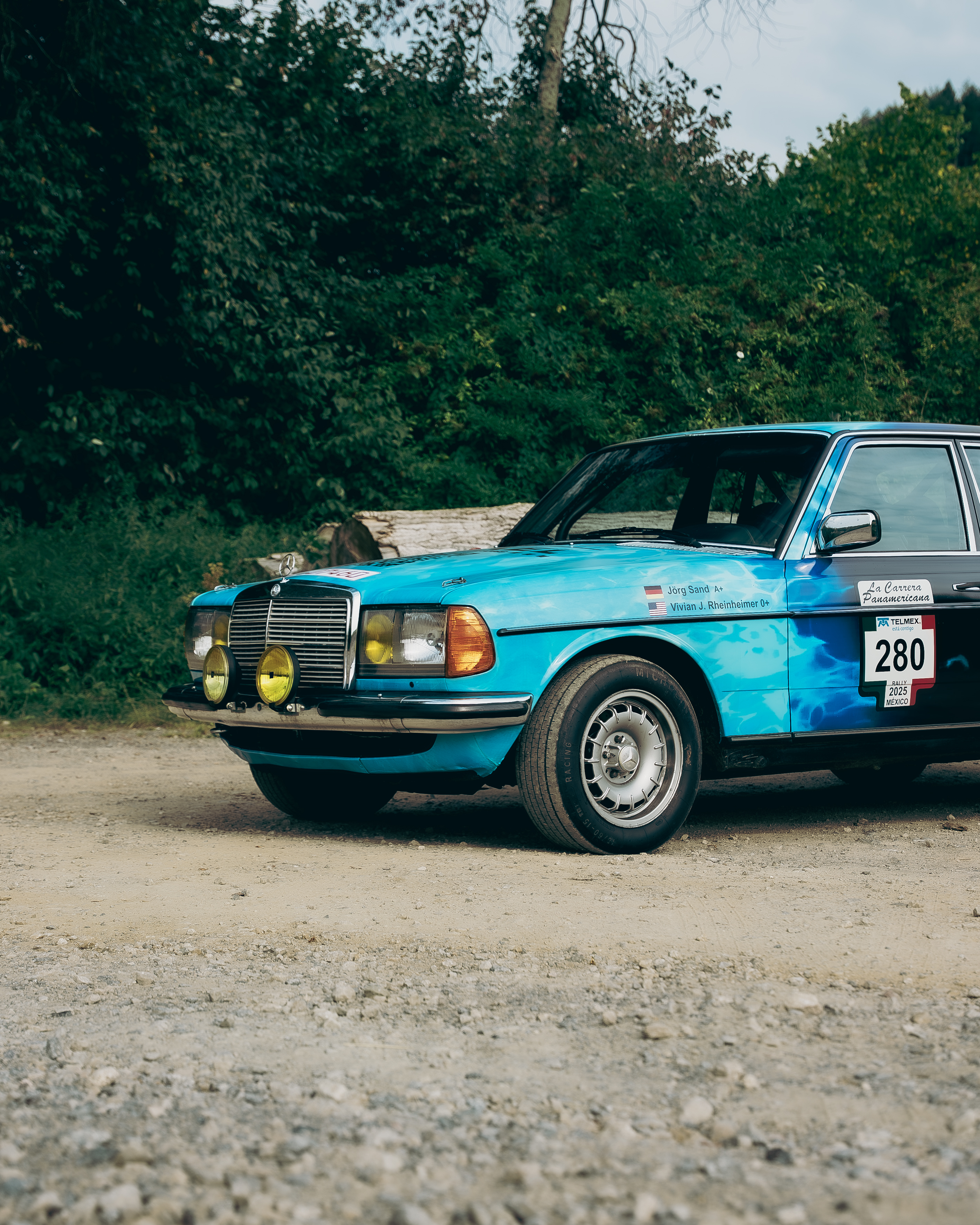 Mercedes-Benz 280E W123 Frontdetail Rallye Detailansicht der Front des Mercedes-Benz 280E W123 mit Mercedes-Stern, gelben Rallye-Scheinwerfern und Carrera-Panamericana-Aufkleber.