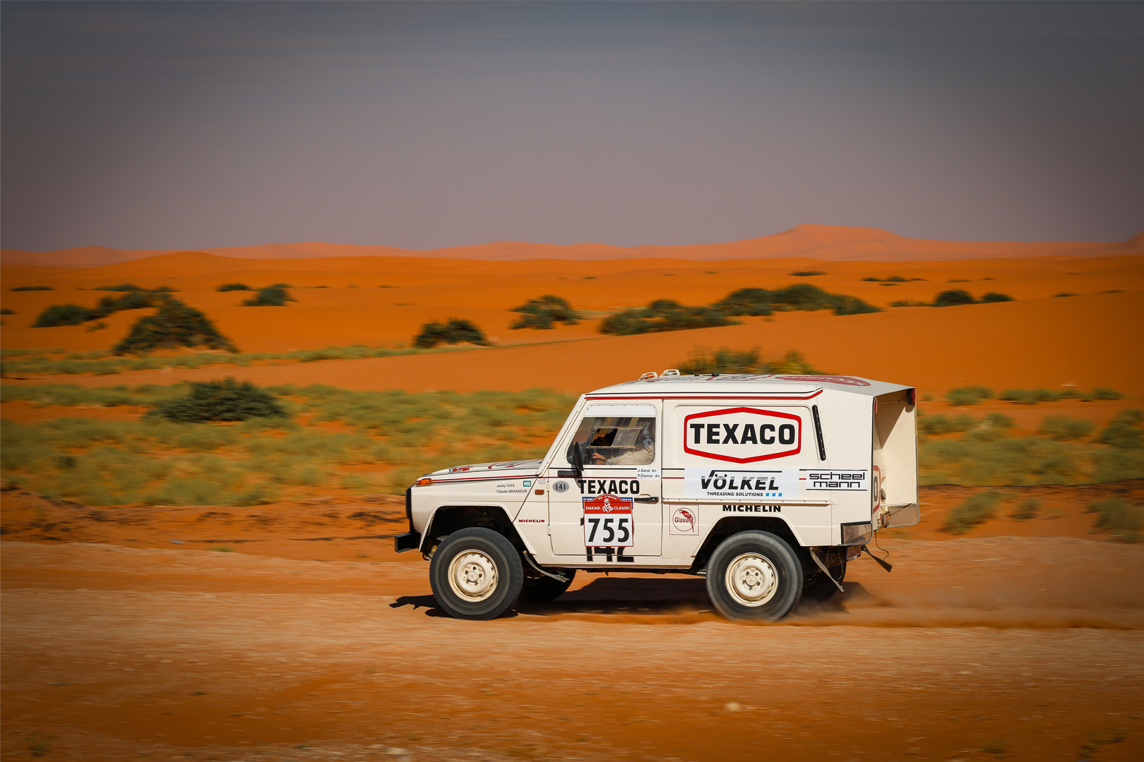 Voiture de rallye numéro 755 sponsorisée par VÖLKEL roulant dans les dunes du Dakar Classic.
