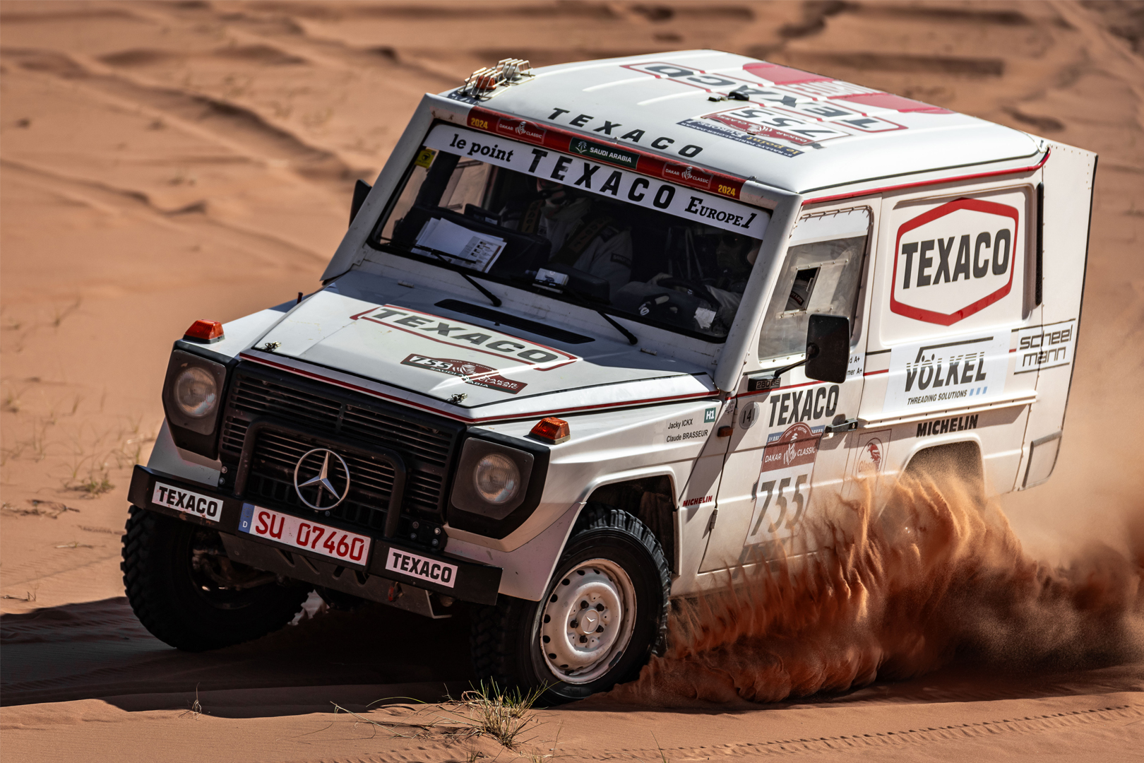 Véhicule tout-terrain Mercedes avec logos Texaco et VÖLKEL dans le désert lors du Dakar Classic.