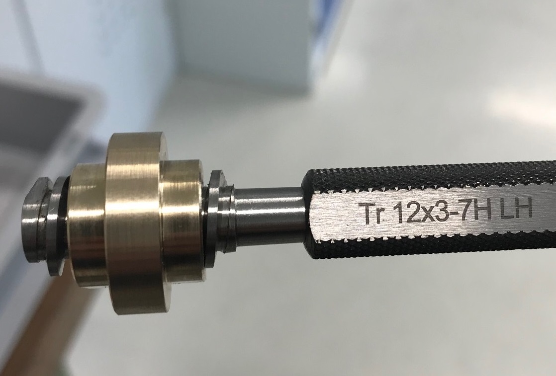 Nahaufnahme eines Lehrdorns mit der Gravur "Tr 12x3-7H LH".