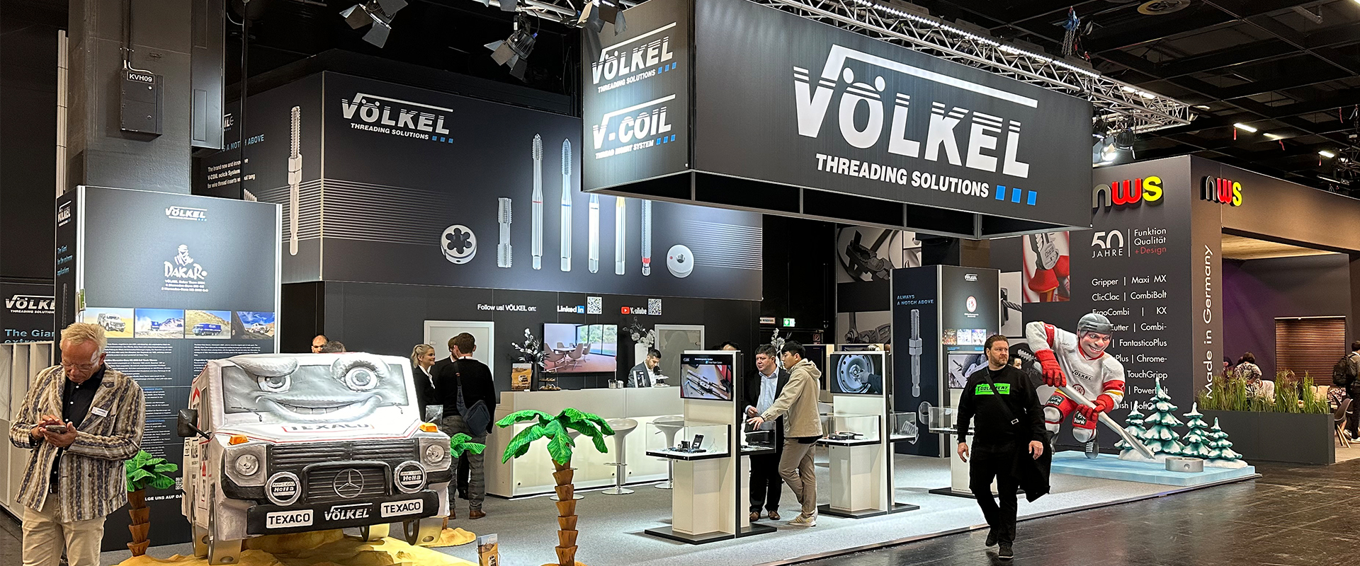 VÖLKEL-Stand mit Gewindeschneidwerkzeugen auf der Eisenwarenmesse 2024, umgeben von Menschen und Displays.