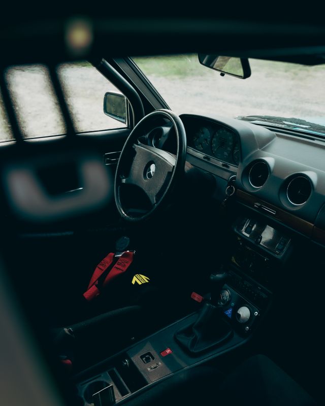 Puesto de conducción del Mercedes-Benz 280E W123 AMG con volante, consola central y arneses